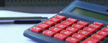 Une calculatrice et un cahier pour calculer l'assurance habitation