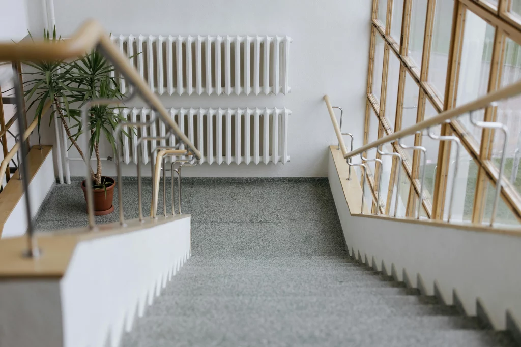 Un escalier dans un immeuble collectif avec un radiateur en face