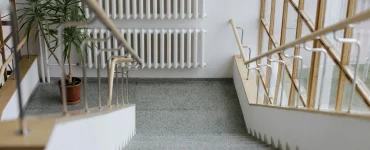 Un escalier dans un immeuble collectif avec un radiateur en face