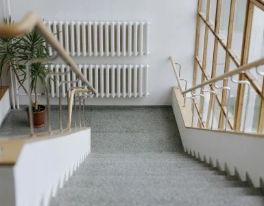 Un escalier dans un immeuble collectif avec un radiateur en face