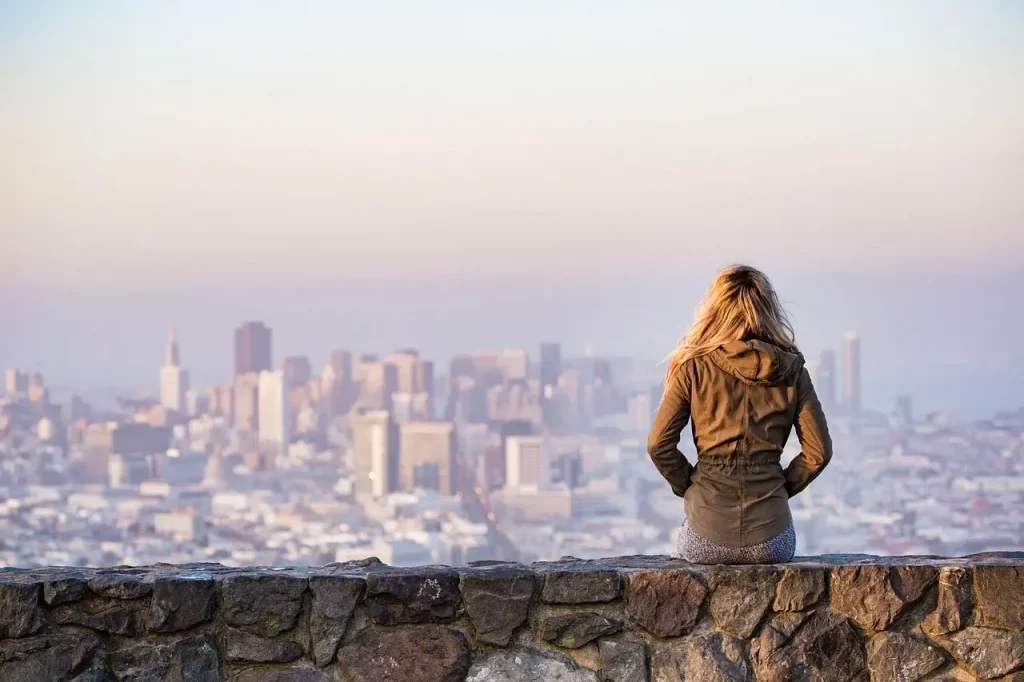 Une jeune femme regardant la ville depuis une allée sur une falaise