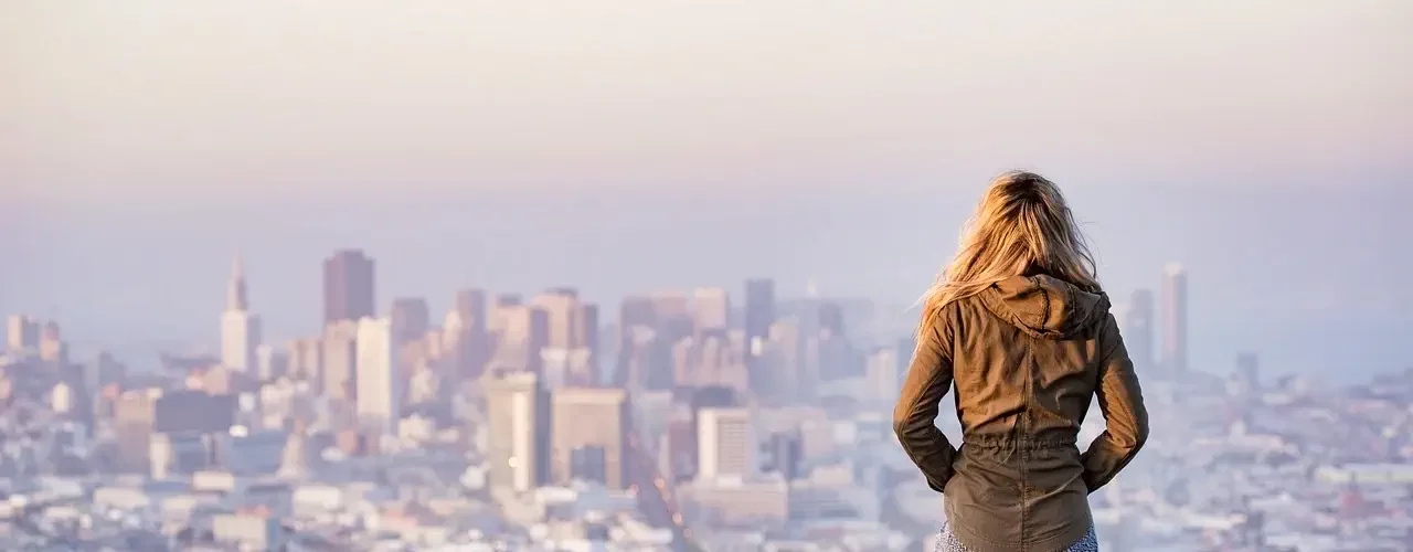 Une jeune femme regardant la ville depuis une allée sur une falaise