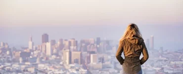 Une jeune femme regardant la ville depuis une allée sur une falaise