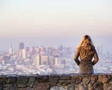 Une jeune femme regardant la ville depuis une allée sur une falaise