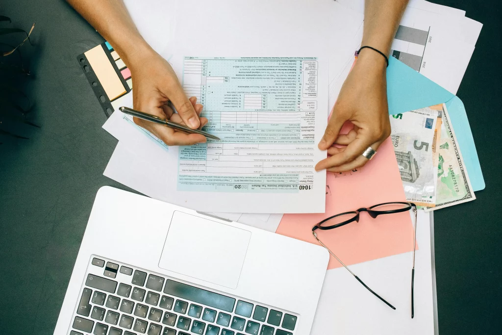 une jeune femme vérifiant ses déclarations fiscales devant un PC