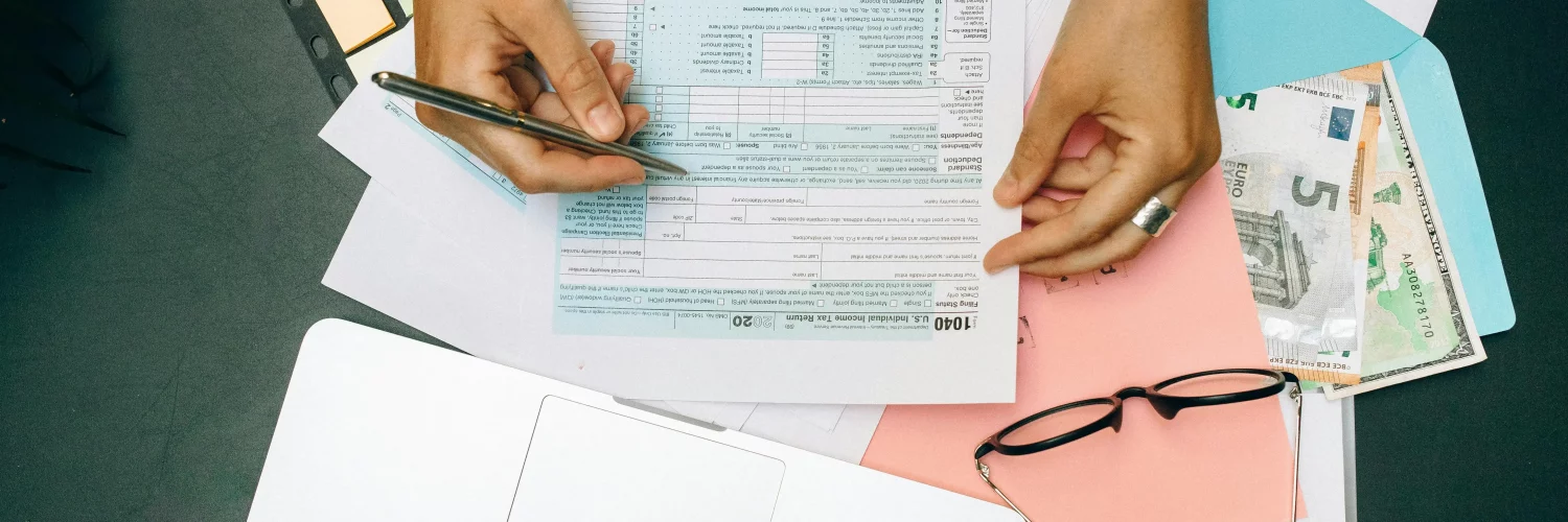 une jeune femme vérifiant ses déclarations fiscales devant un PC