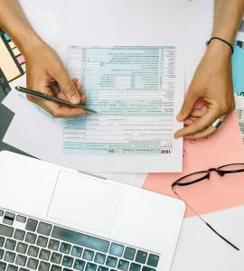 une jeune femme vérifiant ses déclarations fiscales devant un PC