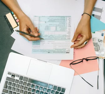 une jeune femme vérifiant ses déclarations fiscales devant un PC