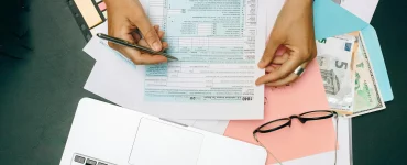 une jeune femme vérifiant ses déclarations fiscales devant un PC