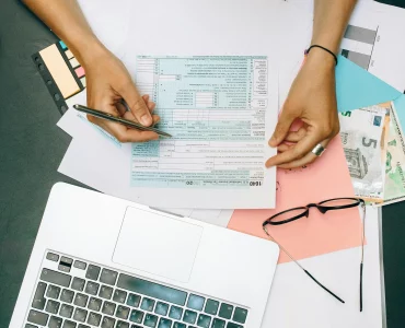 une jeune femme vérifiant ses déclarations fiscales devant un PC