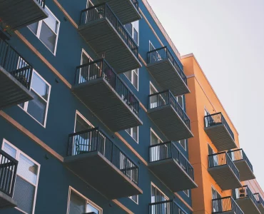 Un immeuble peint en bleu à coté d'un autre en orange