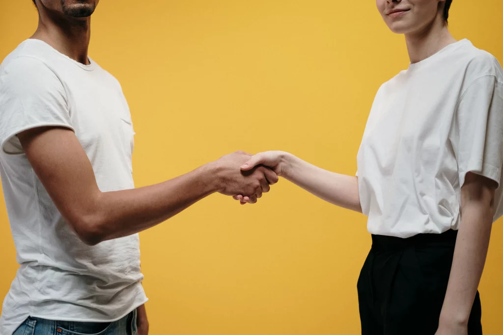 une dame et un homme qui se serrent les mains