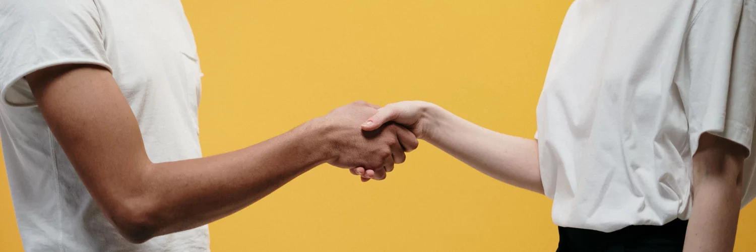 une dame et un homme qui se serrent les mains