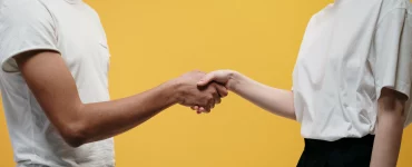 une dame et un homme qui se serrent les mains